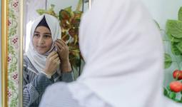 سجود طه البالغة من العمر أربعة عشر عاماً تحاول ترتيب حجابها في مدرسة النصيرات الإعدادية للبنات (أ)، وسط قطاع غزة. جميع الحقوق محفوظة: الأونروا غزة 2017، تصوير تامر حمام