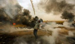 صورة لشاب فلسطيني في مسيرة العودة يصد قنابل الغاز التي يُطلقها الاحتلال بمضرب تنس