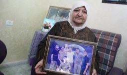 فلسطين المحتلة - أم ناصر أبو حميد تحمل صورة أبنائها الأسرى في سجون الاحتلال