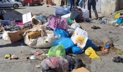 (النفايات تملأ شوارع المخيمات جراء استمرار الأزمة)