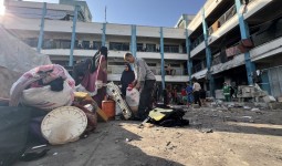 فلسطينيون يتفقدون دمار مدرسة أبو حلو بمخيم البريج بعد قصف 