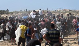 فلسطينيون يتجمعون للحصول على مساعدات تلقى من الجو في أماكن خطرة وسط قطىاع غزة
