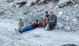 فلسطينيون عائدون إلى خان يونس يجلسون فوق ركام منازلهم