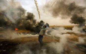 صورة لشاب فلسطيني في مسيرة العودة يصد قنابل الغاز التي يُطلقها الاحتلال بمضرب تنس