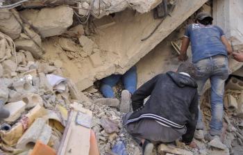 شبّان يبحثون عن الجثث تحت الركام في مخيم اليرموك