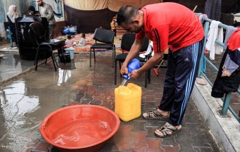 تجميع مياه الأمطار في مراكز الإيواء في غزة للاستفادة منها في الشرب والاستخدام.