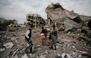 فلسطينيون فوق ركام منازلهم في غزة