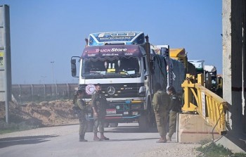 جنود الاحتلال يفتشون شاحنات الهلال الاحمر قبل دخولها