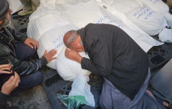 فلسطيني يبكي أفراد عائلته الذين استشهدوا جراء مجزرة 