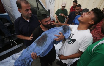 فلسطينيون في مستشفى شهداء الأقصى يبكون طفلاً  قتلته غارة 