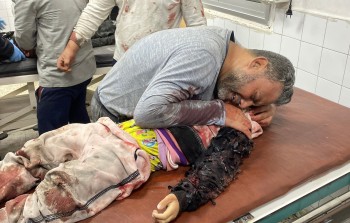 فلسطيني يبكي طفله الشهيد في مستشفى المعمداني بمدينة غزة