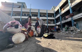 فلسطينيون يتفقدون دمار مدرسة أبو حلو بمخيم البريج بعد قصف 