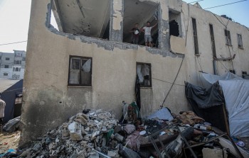 فلسطينيون يتفقدون آثار الدمار بعد غارة استهدفت مدرسة تأوي نازحين في جباليا شمال غزة