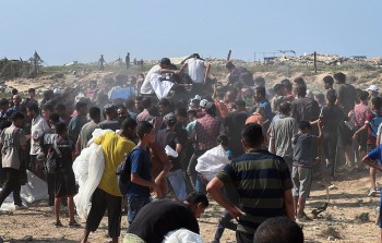 فلسطينيون يتجمعون للحصول على مساعدات تلقى من الجو في أماكن خطرة وسط قطىاع غزة