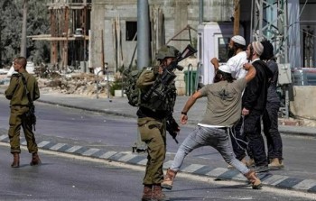 مستوطنون يعتدون على فلسطينيين بحماية من الجيش 