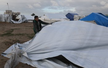 فلسطينيون يحاولون إصلاح خيامهم التي دمرت جراء العواصف الشديدة