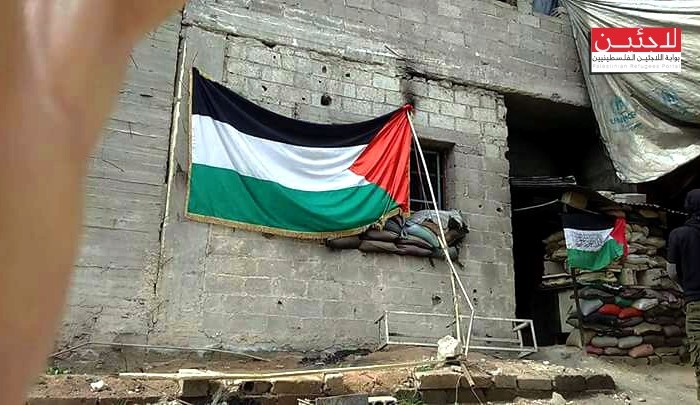 رفع العلم الفلسطيني أمام خطوط التماس مع "داعش"في مخيم اليرموك