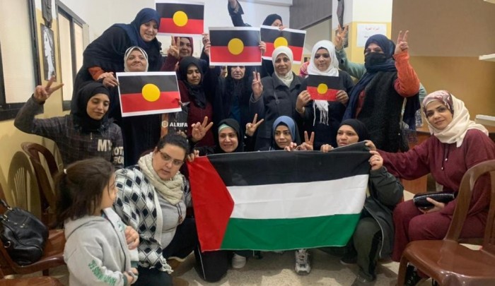 لاجئات فلسطنيات يرفعن علم السكان الاصليين "رحاب شريدي"