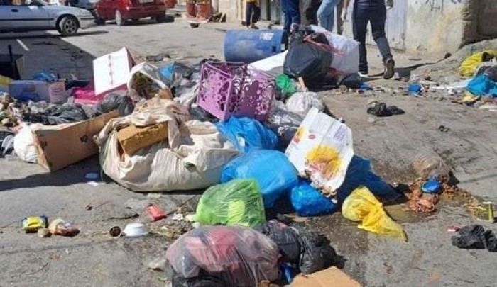 (النفايات تملأ شوارع المخيمات جراء استمرار الأزمة)