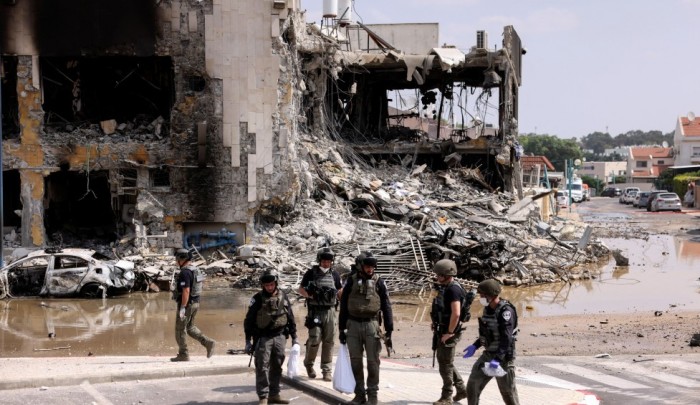 جنود "إسرائيليون" أمام مبنى مدمر في مستوطنة "سديروت"/ رويترز