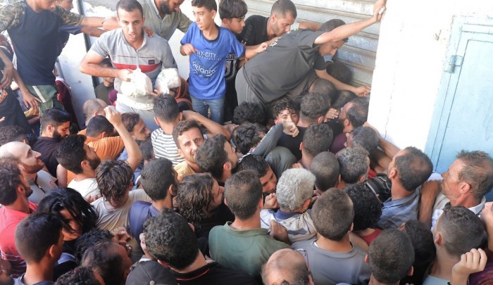 فلسطينيون يتجمهرون أمام مخبز في محاولة الحصول على مادة الخبز/ مخيم النصيرات - صورة أرشيفية