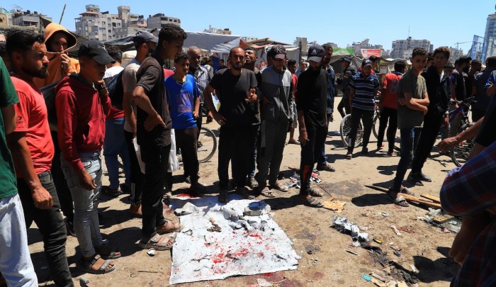 فلسطينيون أمام مكان غارة "إسرائيلية" في غزة