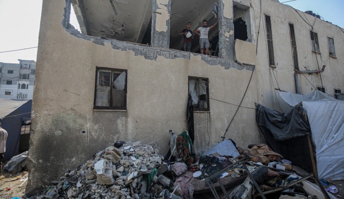 فلسطينيون يتفقدون آثار الدمار بعد غارة استهدفت مدرسة تأوي نازحين في جباليا شمال غزة