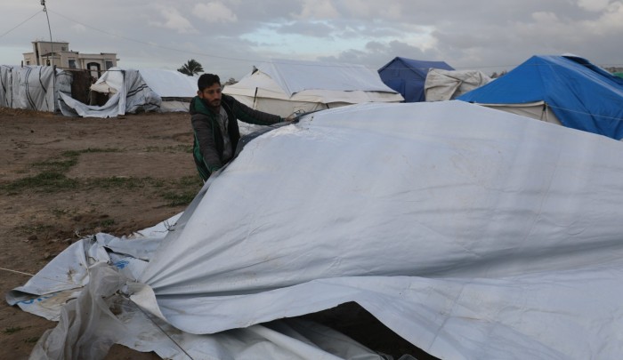 فلسطينيون يحاولون إصلاح خيامهم التي دمرت جراء العواصف الشديدة